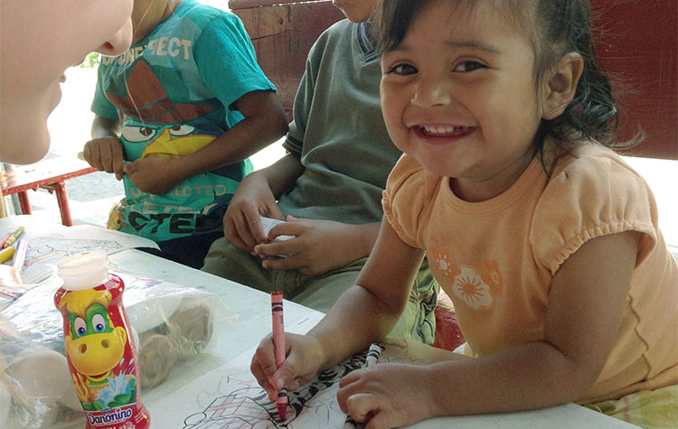 Happy child smiling as she colors